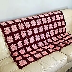 Hand-made Crocheted granny square afgan. About 48" X 60". Pink and wine color.